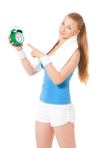 Fitness Woman Holding An Alarm Clock