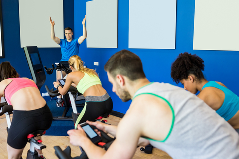Instructor Motivating Students In A Spinning Class